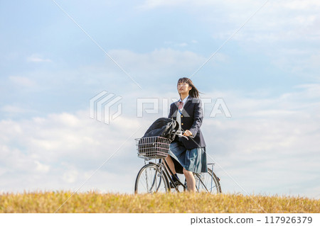 High school girl cycling to school High school girl cycling to school 117926379