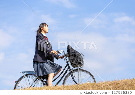 High school girl cycling to school High school girl cycling to school 117926380