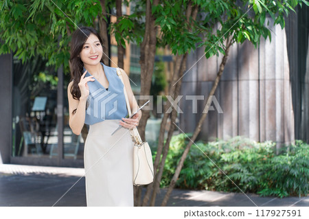Businesswoman holding a tablet device in an office district 117927591