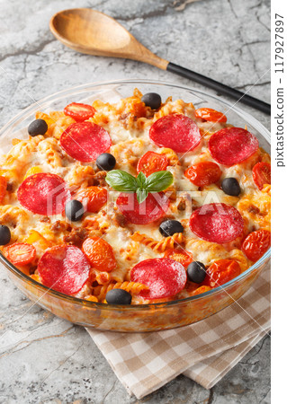 Pizza casserole Pasta baked in a tomato sauce with cheese, sausages, peppers and olives closeup on the in a glass bowl. Vertical Pizza casserole Pasta baked in a tomato sauce with cheese, sausages, peppers and olives closeup on the in a glass bowl. Vertical 117927897
