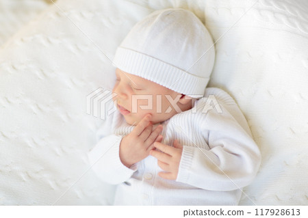Little baby on white bed 117928613