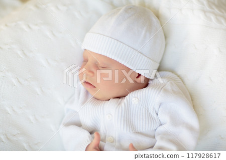 Little baby on white bed 117928617