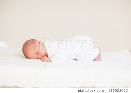 Little baby on white bed 117928622