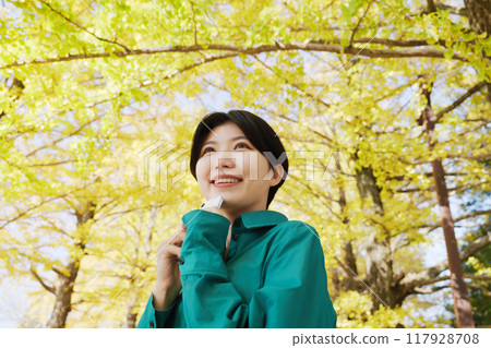 Young woman photographing autumn leaves Young woman photographing autumn leaves 117928708