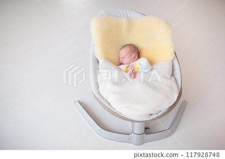 Little baby on white bed 117928748