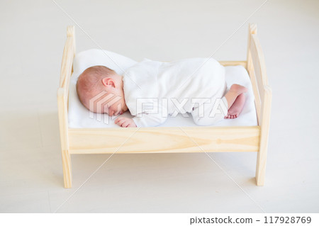 Little baby on toy bed Little baby on toy bed 117928769
