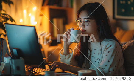 young woman working on laptop at night office 117929260
