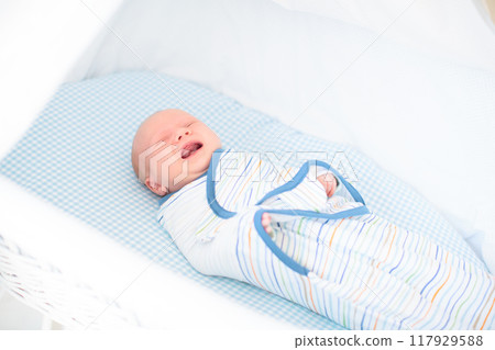 Swaddling newborn child. Baby in swaddle blanket. Swaddling newborn child. Baby in swaddle blanket. 117929588