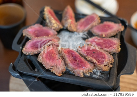 Set of Gyukatsu or beef cutlet on the frying pan. A traditional Japanese food that consists of a deep-fried beef cutlet. Set of Gyukatsu or beef cutlet on the frying pan. A traditional Japanese food that consists of a deep-fried beef cutlet. 117929599