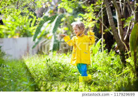 Child playing in the rain. Kid with umbrella. Child playing in the rain. Kid with umbrella. 117929699