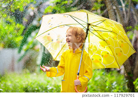 Child playing in the rain. Kid with umbrella. Child playing in the rain. Kid with umbrella. 117929701