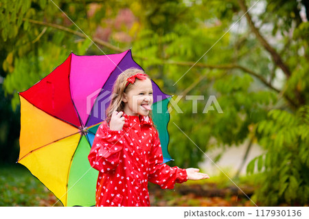 Kid with umbrella playing in summer rain. Kid with umbrella playing in summer rain. 117930136