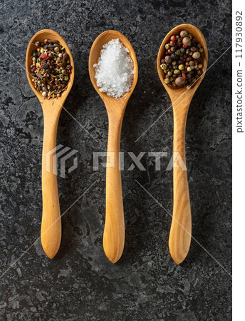 Mix of organic dried spices in wooden spoons. 117930892
