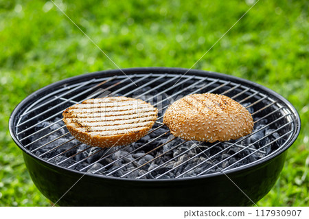 burger bread bun grilling on charcoal grill 117930907