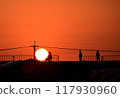 Men watching the sunrise from the bank and a man riding a bicycle 117930960
