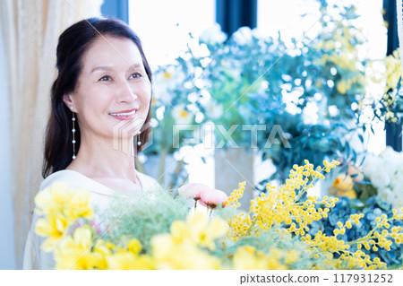 Senior woman surrounded by flowers Senior woman surrounded by flowers 117931252