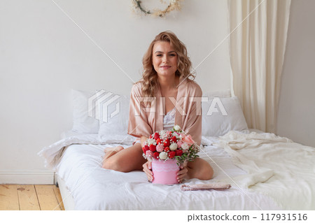 Attractive young woman with romantic gift surprise. Rose flower and strawberry Attractive young woman with romantic gift surprise. Rose flower and strawberry 117931516