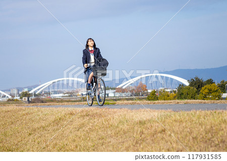 High school girl cycling to school High school girl cycling to school 117931585