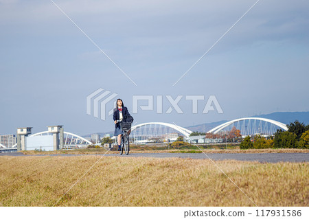 High school girl cycling to school 117931586