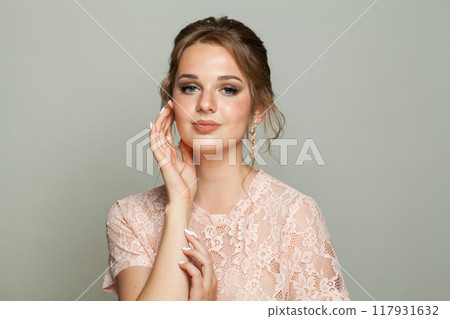 Fashionable good-looking woman with updo hairstyle and makeup. Young female model portrait 117931632