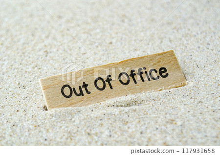 Out Of Office text on wooden stick with beach sand background. Off work and vacation concept. 117931658