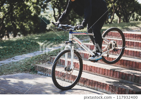 Woman free rider riding bike going down city stairs 117932400