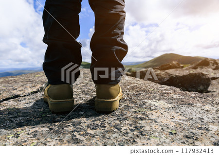 Successful hiker enjoy the view on mountain top cliff edge Successful hiker enjoy the view on mountain top cliff edge 117932413