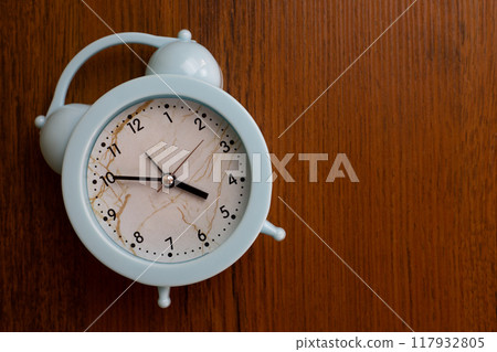 Home alarm clock lies on wooden background with space for text, domestic device to help wake up after healthy deep sleep Home alarm clock lies on wooden background with space for text, domestic device to help wake up after healthy deep sleep 117932805