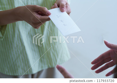 A young woman giving a makeshift otoshidama as a tip A young woman giving a makeshift otoshidama as a tip 117933720