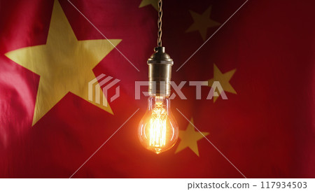 Flickering classic antique Edison Tungsten filament lamp on waving chinese flag background. Raising 117934503
