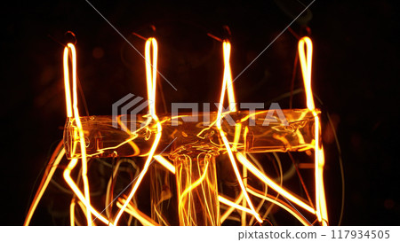 Macro detailed incandescent Edison Tungsten filament lamp flickering, vintage retro bulb. Energy 117934505