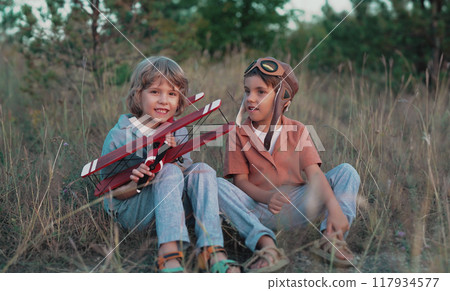 Smiling curious 5 years old preschool children boys playing, discussing aviation with craft wooden Smiling curious 5 years old preschool children boys playing, discussing aviation with craft wooden 117934577