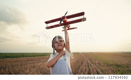 Smiling interested 5 years old child boy playing with wooden airplane, discovering future profession Smiling interested 5 years old child boy playing with wooden airplane, discovering future profession 117934592