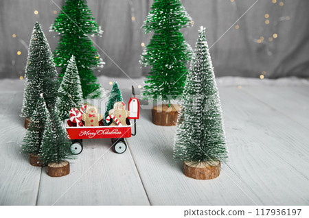 Merry Christmas and Happy New Year greeting card. Gingerbread men and lollipops in a cart with Christmas trees and copy space Merry Christmas and Happy New Year greeting card. Gingerbread men and lollipops in a cart with Christmas trees and copy space 117936197
