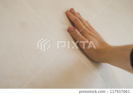 closeup young man hand touching plastered wall closeup young man hand touching plastered wall 117937061