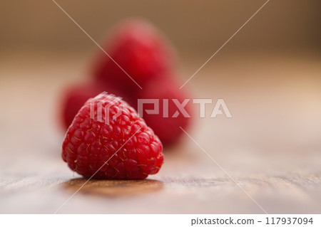 Ripe raspberries on wood background 117937094