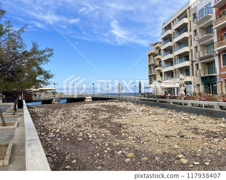 View of the promenade in Marsalforn Bay  (Salt Pans) at Gozo, Malta at sunny day with some clouds 117938407