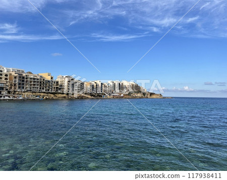 View of the promenade in Marsalforn Bay  (Salt Pans) at Gozo, Malta at sunny day with some clouds 117938411