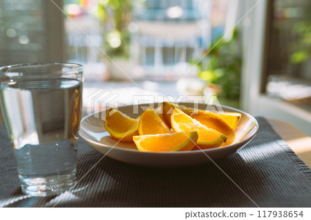 peeled oranges and glass water on table peeled oranges and glass water on table 117938654