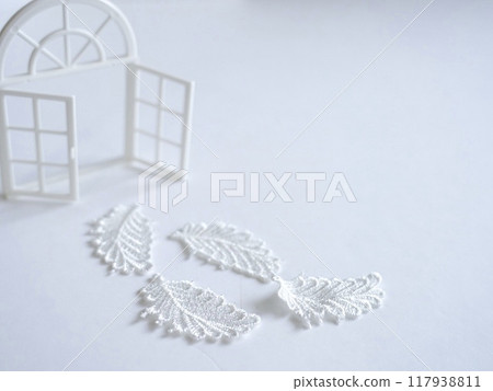 A solemn atmosphere with a white window frame and white leaves on a white background A solemn atmosphere with a white window frame and white leaves on a white background 117938811