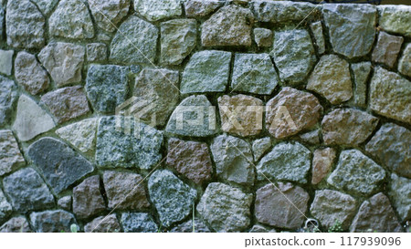 Stone wall texture background. The wall of the building is lined with stones. The stones in the wall are of medium size 117939096