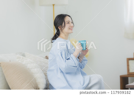 年輕女子在沙發上喝咖啡 117939182