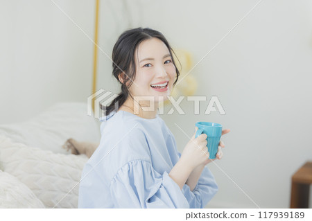 年輕女子在沙發上喝咖啡 年輕女子在沙發上喝咖啡 117939189