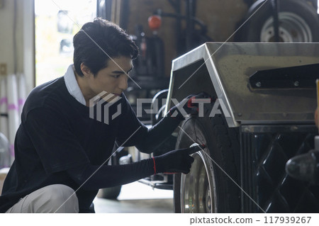 一名男子正在檢查一輛卡車 117939267