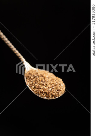 Ground coriander natural spice in a spoon, black background Ground coriander natural spice in a spoon, black background 117939390