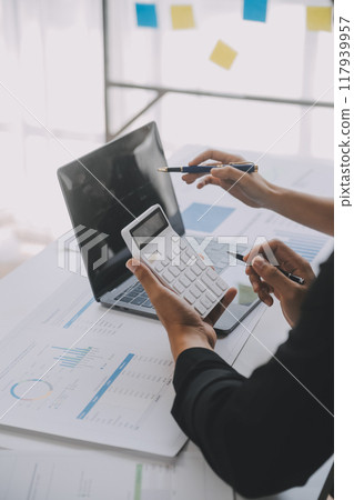 Financial analysts analyze business financial reports on a digital tablet planning investment project during a discussion at a meeting of corporate showing the results of their successful teamwork. Financial analysts analyze business financial reports on a digital tablet planning investment project during a discussion at a meeting of corporate showing the results of their successful teamwork. 117939957