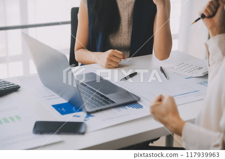 Financial analysts analyze business financial reports on a digital tablet planning investment project during a discussion at a meeting of corporate showing the results of their successful teamwork. 117939963