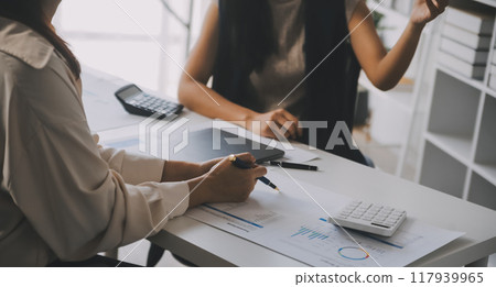 Financial analysts analyze business financial reports on a digital tablet planning investment project during a discussion at a meeting of corporate showing the results of their successful teamwork. 117939965