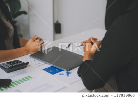 Financial analysts analyze business financial reports on a digital tablet planning investment project during a discussion at a meeting of corporate showing the results of their successful teamwork. 117939966