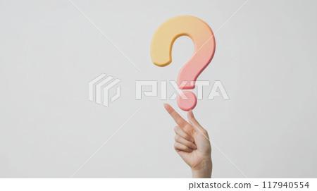 Finger balancing a pastel-colored foam question mark on a plain background. Image symbolizing inquiry, curiosity, and knowledge. Finger balancing a pastel-colored foam question mark on a plain background. Image symbolizing inquiry, curiosity, and knowledge. 117940554